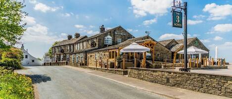 A traditional stone building with a sign reading "The 3 Acres."