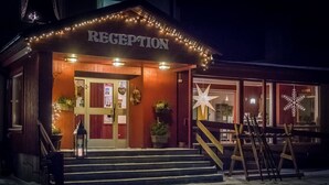 Et receptionområde med træfacade, et skilt over indgangen og en stjernepyntning på vinduet.