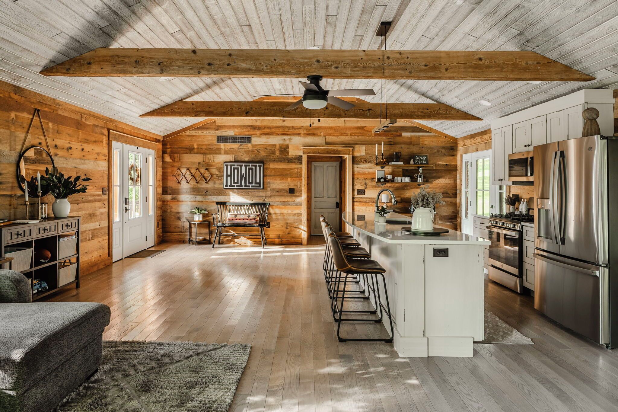A spacious kitchen with wooden walls, a central island, and modern appliances.
