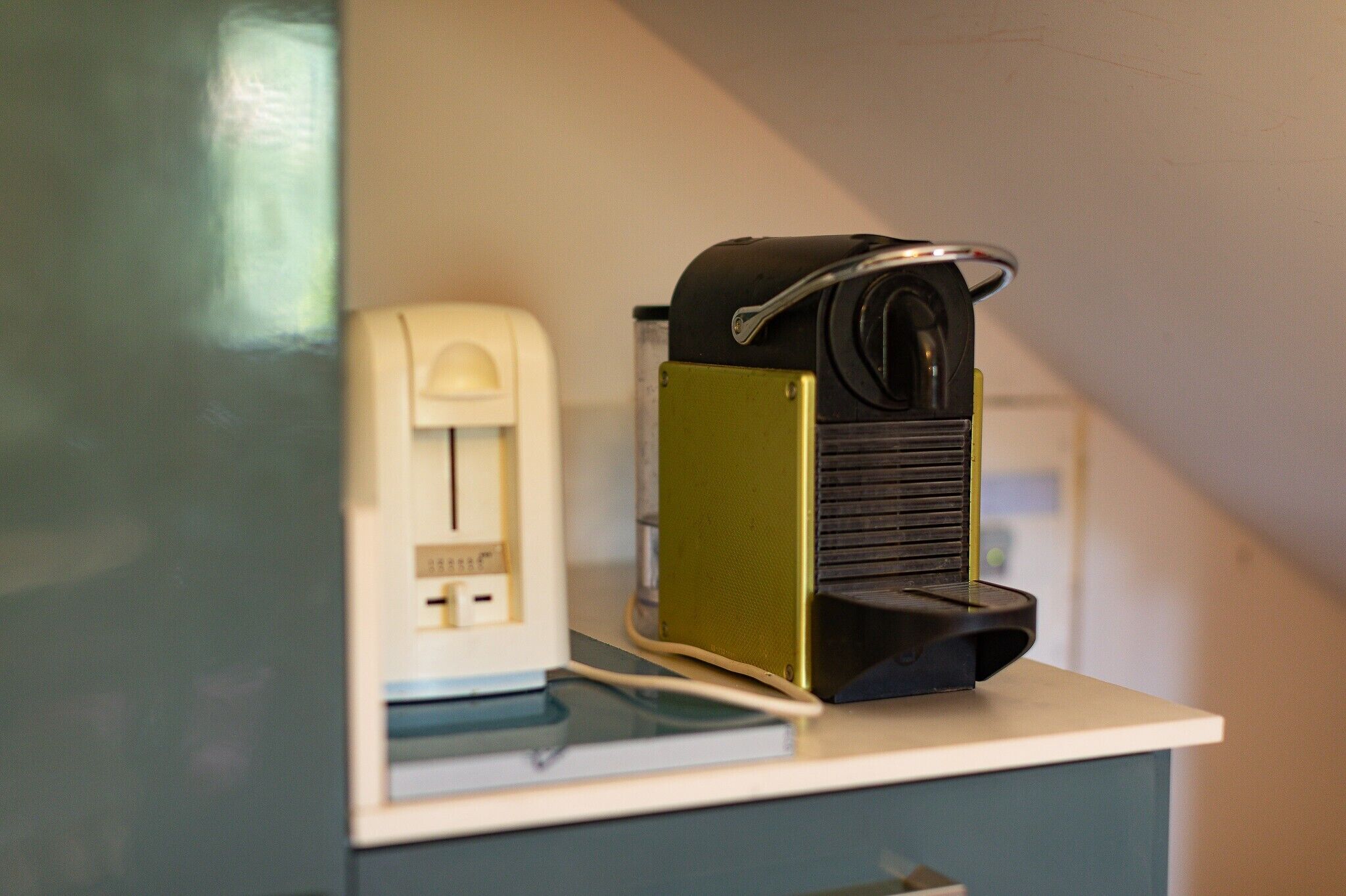 Une pièce équipée d’un bureau, d’un téléphone et d’un petit appareil électroménager.