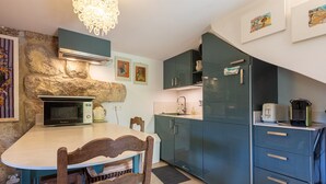 Una cocina con pared de piedra, microondas, fregadero y armarios.