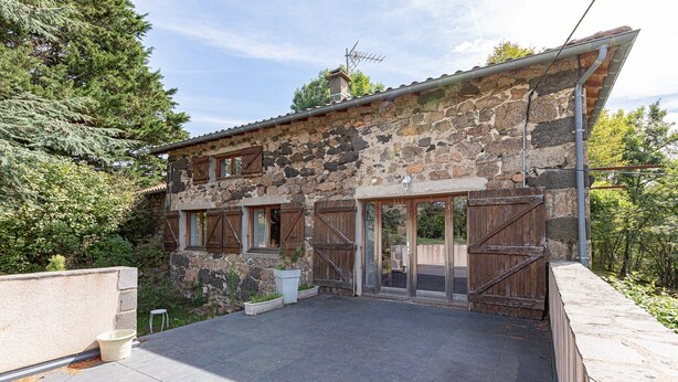 A stone building with a patio, wooden shutters, and a metal roof. - Country House 'La Gabbro' with Mountain View, Private Terrace and Wi-Fi (Saint-Barthélemy-Grozon)