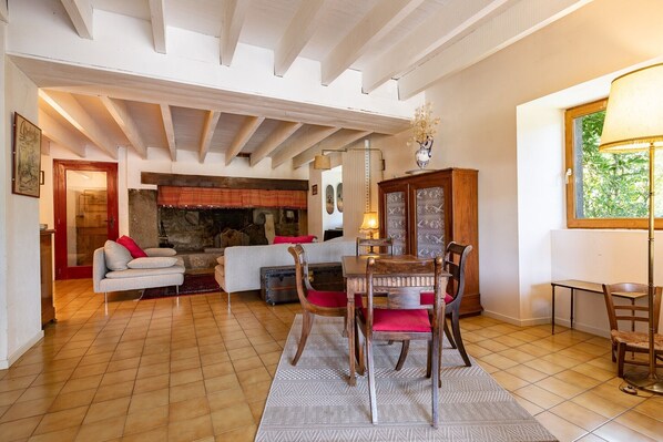 A living room with a fireplace, wooden furniture, and a dining area.