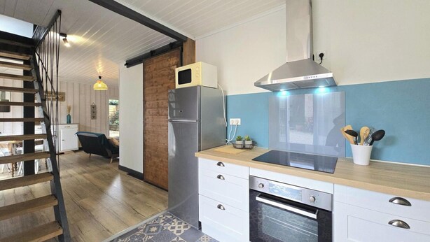A modern kitchen with a built-in oven, a microwave, and a stainless steel refrigerator.