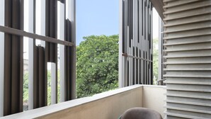 A modern balcony with a round table, a chair, and a small potted plant. - Saltstayz Premier Naraina Central Delhi (New Delhi)