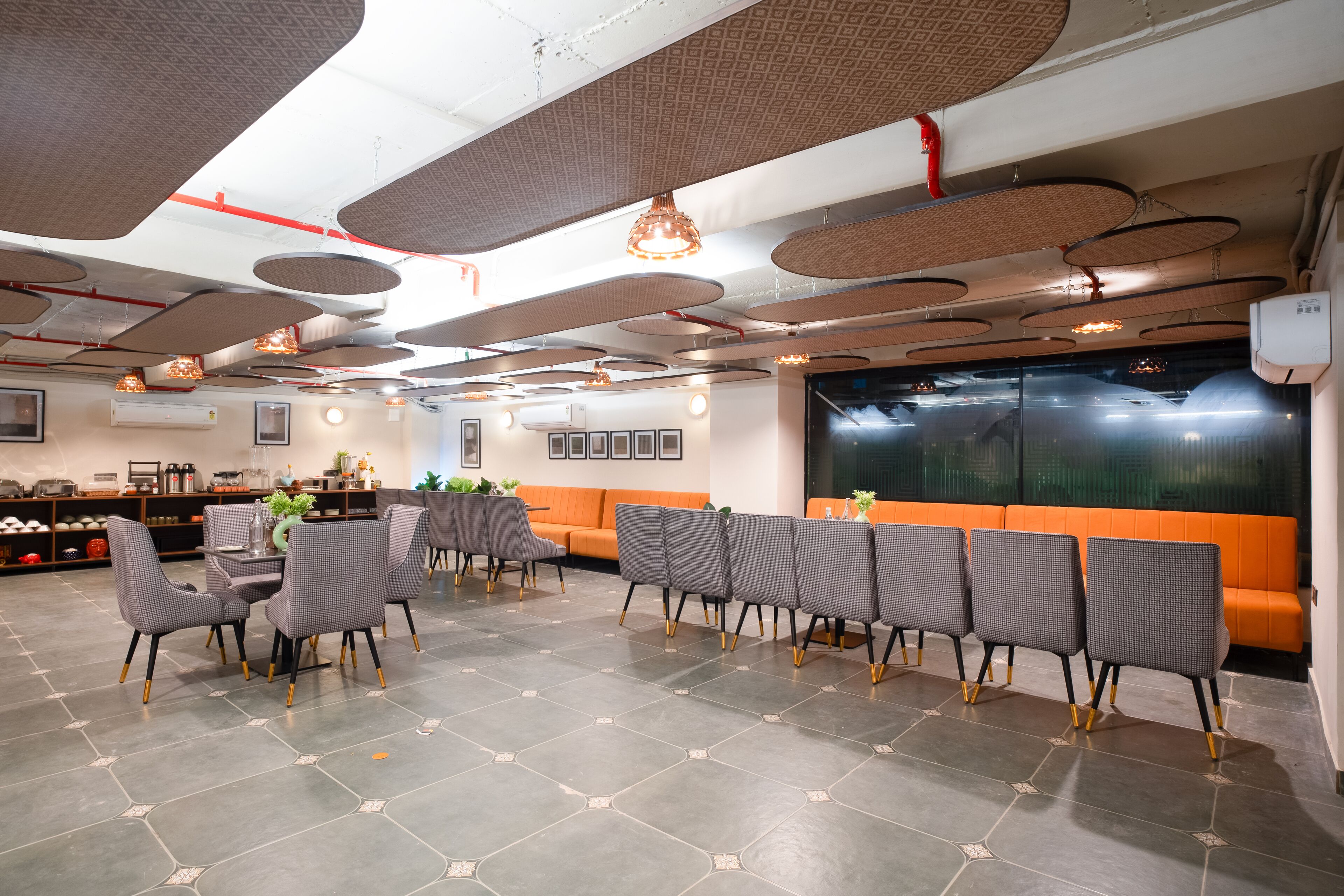 A modern interior with a dining area featuring grey upholstered chairs and a table with a vase of flowers.