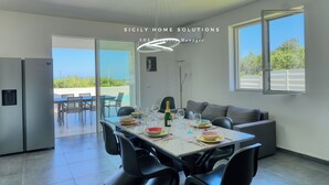 Un comedor moderno con una mesa dispuesta para cuatro personas, un refrigerador y vistas al exterior.