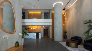A modern lobby with a reception desk, two floors, and a central column.