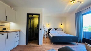 Un dormitorio moderno con cama, mesita de noche y vistas al exterior.