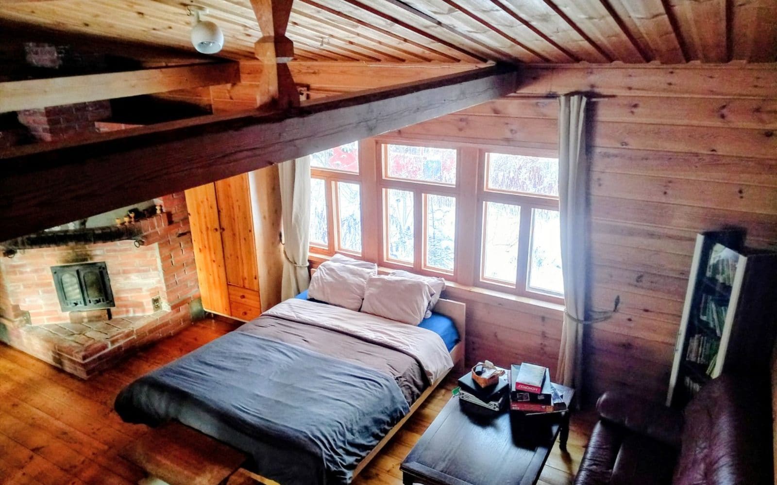 A cozy room with a bed, a fireplace, and a window.