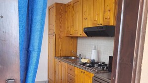 A kitchen with wooden cabinets, a stove, and a dishwasher.