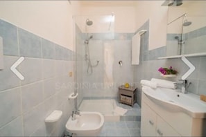 Ein Badezimmer mit Dusche, Waschbecken und Toilette.