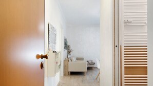Un couloir menant à une chambre à coucher équipée d’un lit, d’une table de chevet et d’un miroir.