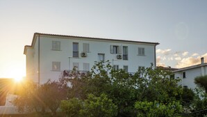 A multi-story building with balconies and air conditioning units. - Charming Baia Marina apartment (Orosei)