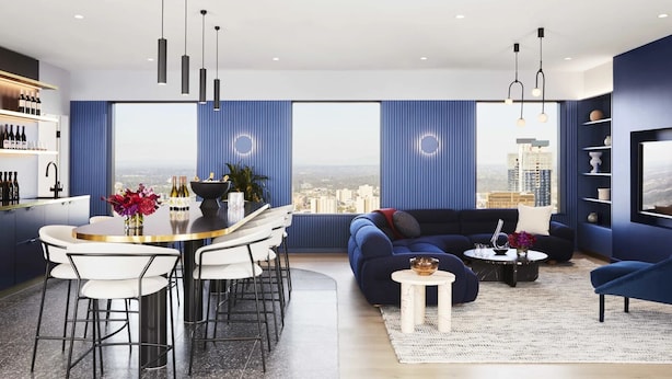 A modern living room with a city view, a dining area with a round table, and a bar with bottles.