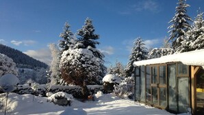A snow-covered landscape with a glass greenhouse structure. - Apartment 'Hüsli' with Mountain Views, Shared Terrace, and Wi-Fi (Titisee-Neustadt)