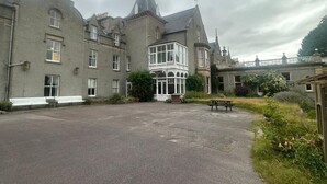 A large building with multiple windows and a central courtyard. - Cluny Hill Hotel (Forres)