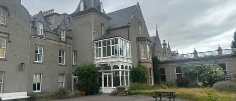 A large, historic building with multiple windows and a prominent bay window.