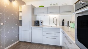 A compact kitchen with white cabinets, a coffee maker, and a sink. - Apartment '7' with Shared Garden and Wi-Fi (Willingen (Upland))