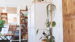 A kitchen with wooden flooring, a white refrigerator, and a wooden sliding door.