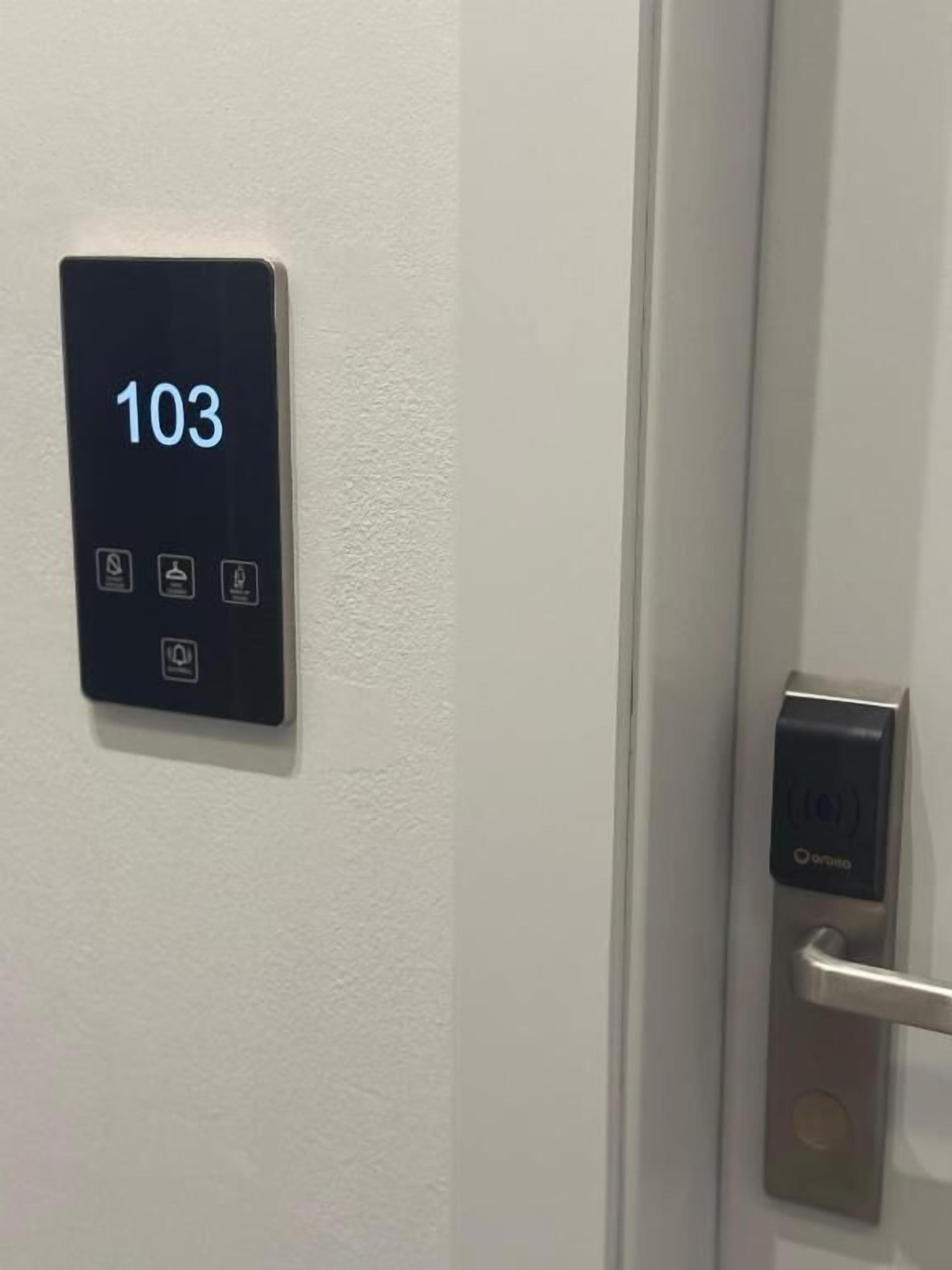Ein digitales Türschloss mit einer Ziffernanzeige, die '103' anzeigt und einem Ziffernfeld.