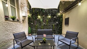 Un patio con dos sillas, una mesa y una planta en maceta.