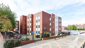 A multi-story building with a sign indicating it is Queens Court. - Student Only Queens Court (Leicester)