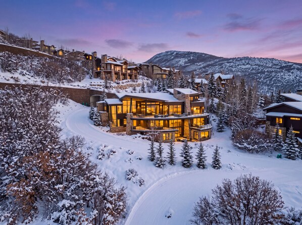 Un edificio de varios pisos con grandes ventanales y un paisaje cubierto de nieve.
