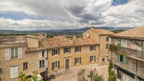 A historic building with a tiled roof, stone walls, and traditional shutters. - Charming 2-Bed Appartment in the heart of Mougins with AC, near Cannes (Mougins)