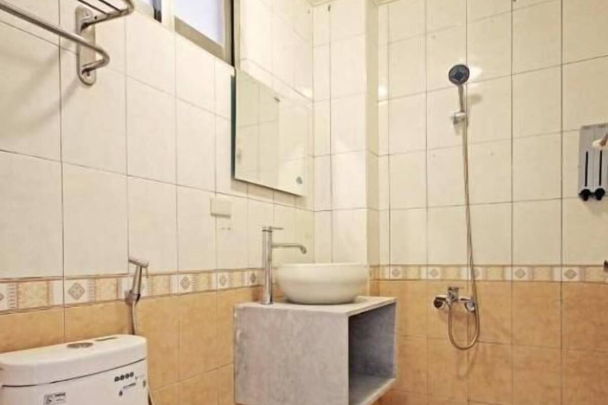 A bathroom with a toilet, sink, and shower.