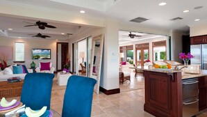 A spacious living area with a kitchen, dining area, and a large window providing a view of the outdoors. - Villa La Percha With 4 Bedrooms and 4 5 Bathrooms (Providenciales)