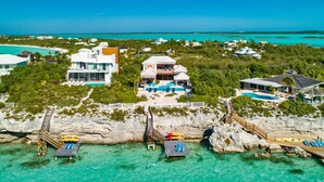 An aerial view of a coastal property with multiple buildings, a swimming pool, and a dock with boats. - Villa La Percha With 4 Bedrooms and 4 5 Bathrooms (Providenciales)