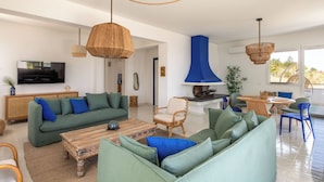 A spacious living room with a large green sofa, a wooden coffee table, and a dining area with a round table and chairs. - Sea Frame Design Apartments with Pool by Wonderful Italy (Santa Flavia)