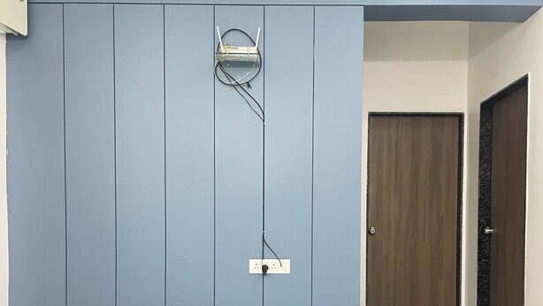 Ein Zimmer mit blauer Wand, Holztür und Fliesenboden.