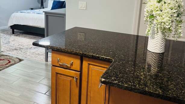 Una cocina moderna con armarios de madera y encimera de granito.