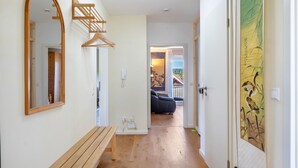 A hallway with a wooden bench, a mirror, a coat rack, and a door with a painting. - Apartment "Haus Rosengarten" with Balcony and Wi-Fi (Friedenweiler)