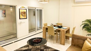 Una sala de estar moderna con comedor, que cuenta con un panel de vidrio, ventilador de techo y aire acondicionado.