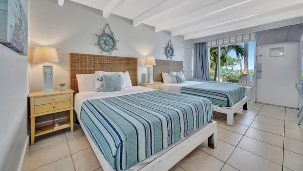 A hotel room with two beds, a large window, and a view of palm trees. - The Beach! | Pool, Hot Tub, Gym, Game Room, Tennis (Ruskin)