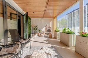 A modern outdoor lounge area with seating, planters, and a wooden ceiling. - BeachTime Apartments & SPA Grzybowo by POSESJA APARTAMENTY (Grzybowo)