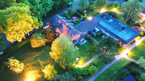 An aerial view of a house with a large yard, surrounded by trees and a pond. - Gemütliche 2,5 Zimmer unter Reet in SPO (Sankt Peter-Ording)