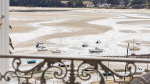 A coastal view with boats on a sandy beach, a fence in the foreground, and houses in the background. - Charming Apartment in Locquirec with Sea View (Locquirec)