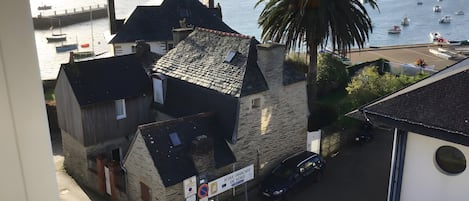 Un bâtiment en pierre avec un toit en pente, une voiture garée et un panneau indiquant la présence d’un terrain de golf à proximité.