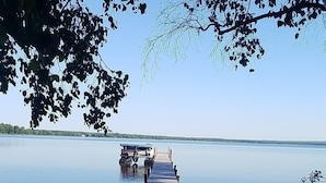 Een houten steiger die zich uitstrekt over kalm water, omringd door bomen.