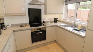 A modern kitchen with a stove, oven, and sink. - 22 Old Chapel Close (Kidlington)