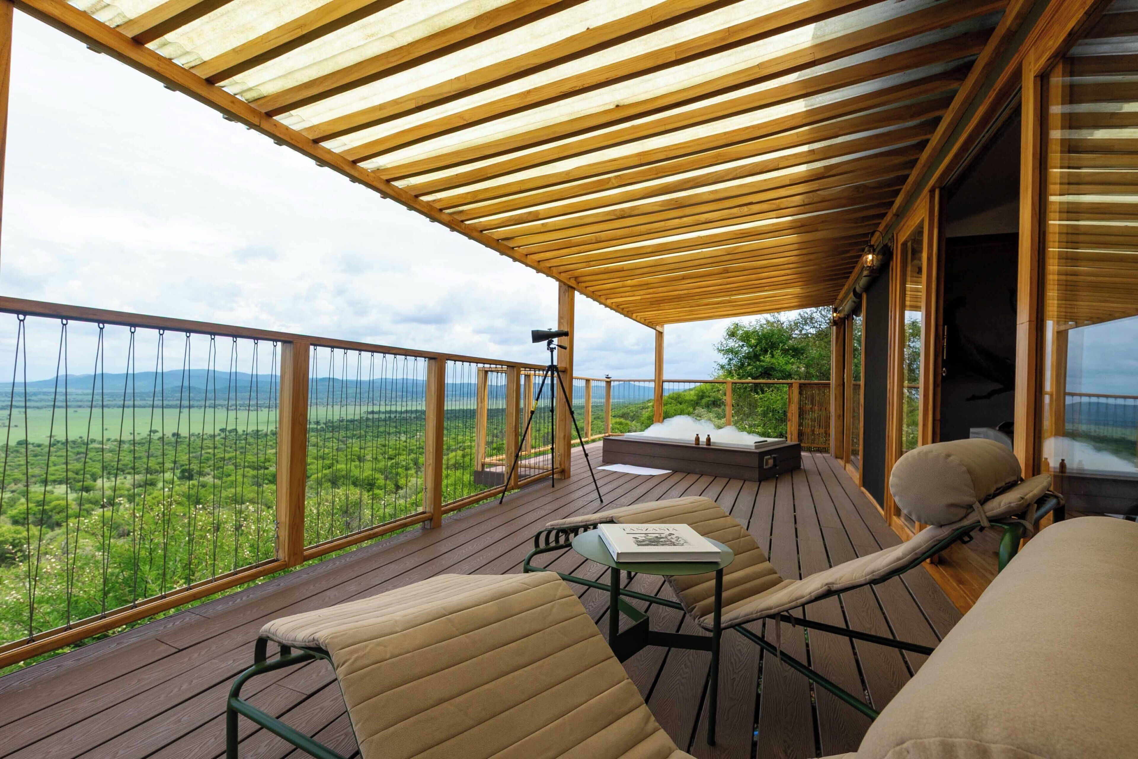 Una terraza de madera con mobiliario exterior, un telescopio y vistas del paisaje.