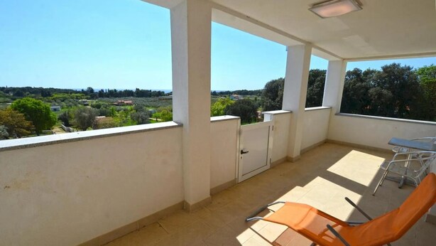 A balcony with a view of a rural landscape, a table, and two orange chairs. - Apartment Mare e Vista (Rovinj)