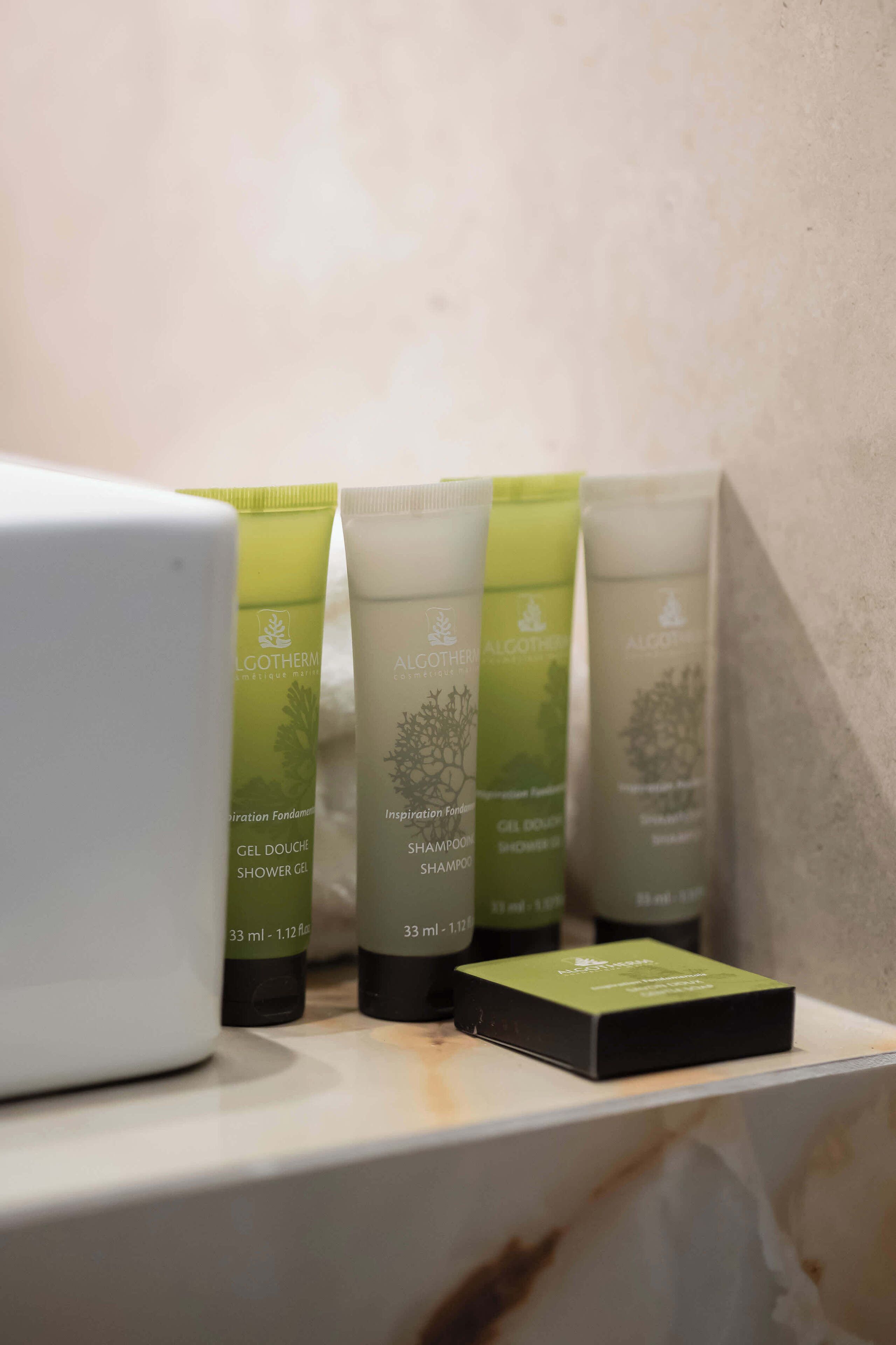 A bathroom sink area with a mirror, light walls, and neatly arranged toiletries.
