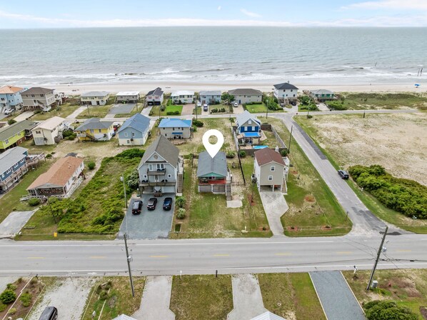 Une zone résidentielle côtière comprenant des maisons, une route et une plage.