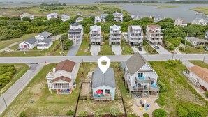 Una zona residenziale sul lungomare, con case, una piscina e vista mare.