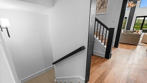 A staircase with a black handrail leading to a landing.